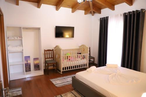 a bedroom with a crib and a baby crib at Vila Mulliri Gjeroven in Berat