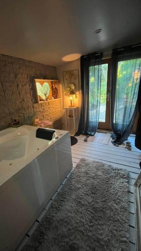 une grande salle de bain avec une baignoire et une grande fenêtre dans l'établissement La cabane des amoureux du jardin, à Barjols