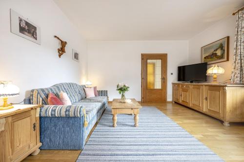 a living room with a blue couch and a tv at Panorama Apartments Walter in Ortisei
