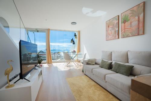 a living room with a couch and a tv at CasaNova by LovelyStay in Santa Cruz