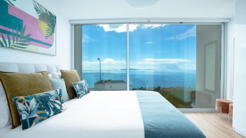 a bedroom with a bed and a large window at CasaNova by LovelyStay in Santa Cruz