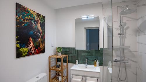 a bathroom with a sink and a painting on the wall at CasaNova by LovelyStay in Santa Cruz