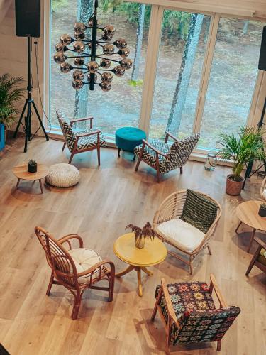 a living room with chairs and tables and a chandelier at Tuba järveäärses puhkemajas - Saarjärve Puhkemaja in Tromsi