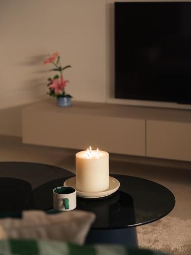 a candle sitting on a table with a cup of coffee at Brassbell Zamalek Diplomatic Zone Near Marriott in Cairo