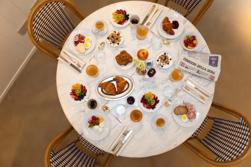 a white table with plates of food on it at Hotel Sablé in Marina di Pietrasanta