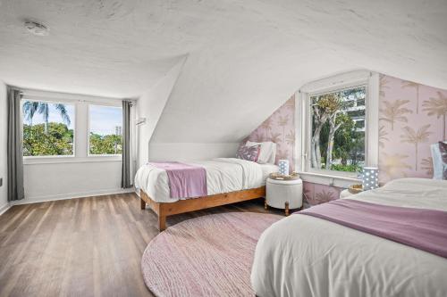 a bedroom with two beds and two windows at Heated Pool Grill Fire Pit & Cold Plunge Sleeps 8! in West Palm Beach