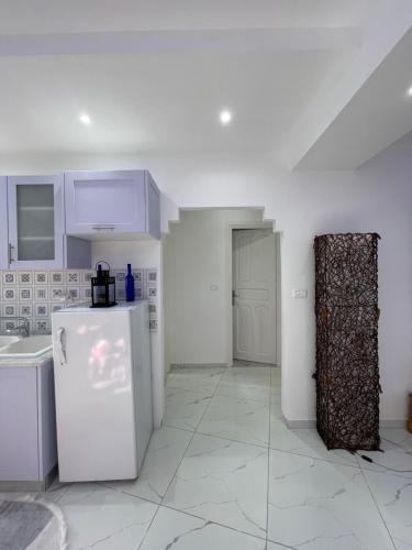 a kitchen with white cabinets and a refrigerator at The center of sidi bou said The Blue & White Perle 1 in Dar Mimoun Bey