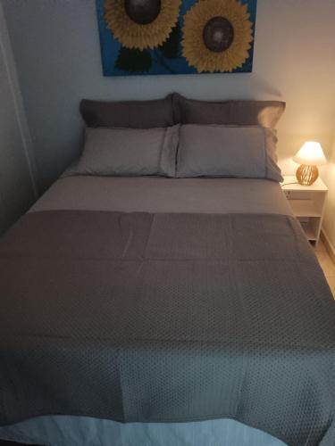 a bed in a bedroom with two sunflowers on the wall at Espaço Van Gogh in Campinas