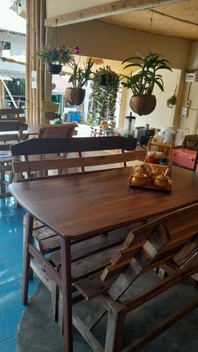 a wooden table in a room with potted plants at Bamboo Hut Resort and Restaurant in Ko Man Nai
