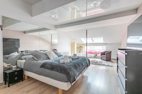 une chambre avec un grand lit et un salon dans l'établissement Le Faubourg Saint Martin Senlis, à Senlis