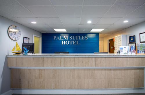 a hospital reception counter with a sign that reads palm suites hotel at Palm Suites in Atlantic Beach