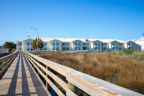 a wooden boardwalk leading to a beach house at Palm Suites in Atlantic Beach