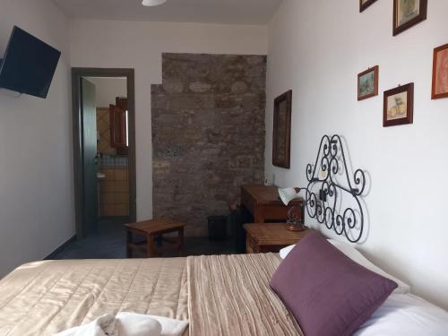 a bedroom with a bed and a stone wall at Agriturismo Terrenia in Taormina