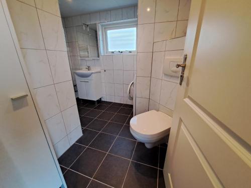 a small bathroom with a toilet and a sink at Sweltsje in Sprong