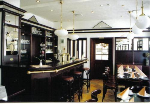 帕希姆的住宿－漢堡斯塔迪特卜瑞吉酒店，餐厅内的酒吧,配有桌椅