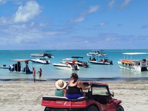 eine Gruppe von Menschen, die in einem Golfwagen am Strand fahren in der Unterkunft Hospedagem da barra suites,praia barra grande,caminho de moises e antunes in Maragogi