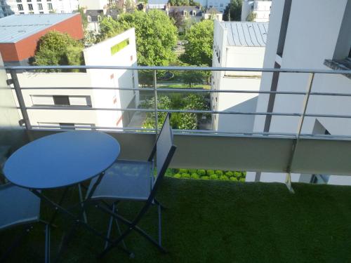 une table et des chaises sur un balcon avec vue dans l'établissement Studio meublé 1 personne - Centre-ville Mail François Mitterrand, à Rennes