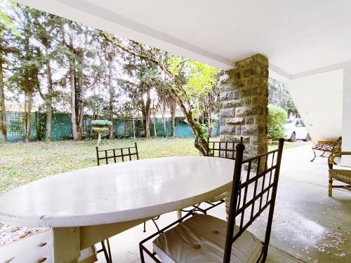 a white table and chairs on a patio with trees at Le Marcel Terrasse jardin in Auch