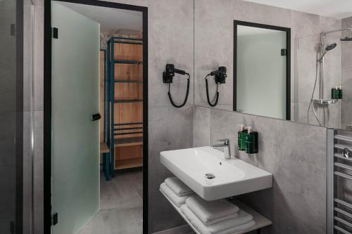 a bathroom with a sink and a mirror at EA Hotel Moment Self Check-In in Prague