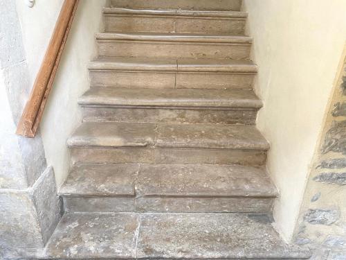 a set of stairs in a building with cement at Maison Galop Marin in Saint-Côme-du-Mont