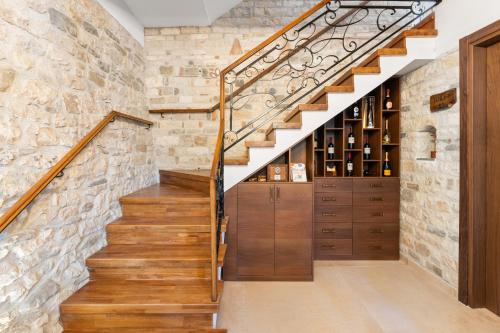 a staircase with wooden cabinets and a stone wall at GrandView Hotel in Berat