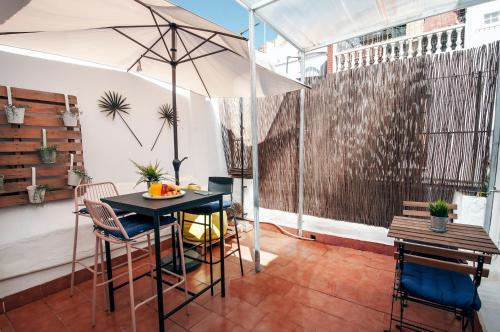 a patio with a table and chairs and an umbrella at ATP San Cristóbal a 5 minutos de Puerta Purchena - Alcazaba - Catedral - Wifi Gratis! in Almería