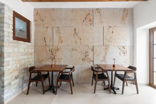 two tables and chairs in a room with a brick wall at GrandView Hotel in Berat