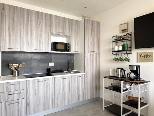 a kitchen with wooden cabinets and a sink and a microwave at Aquavista Residence - Lakeview Holiday Apartments with Pool in Dormelletto