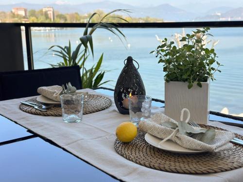 a table with a table set up for a meal with a view at Aquavista Residence - Lakeview Holiday Apartments with Pool in Dormelletto