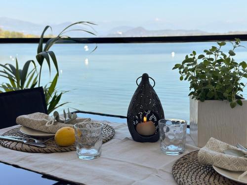 a table with a candle on it with a view of the water at Aquavista Residence - Lakeview Holiday Apartments with Pool in Dormelletto