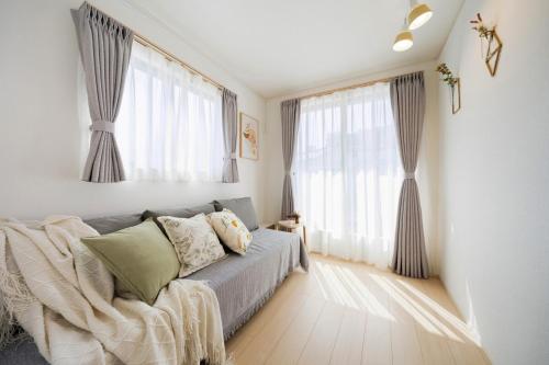 a bedroom with a bed and two large windows at Magazine Home Tokyo Spacious 93 3BR Skytree7 minutesAsakusa12 minutes by train in Tokyo