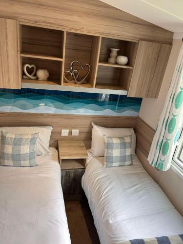 two beds in a small room with shelves and windows at Edinburgh, Seton Sands, The Fishing Boat in Port Seton