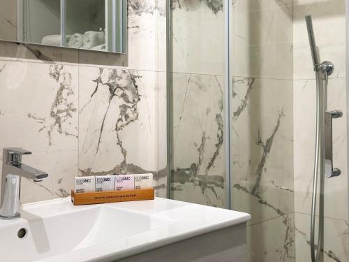 a bathroom with a sink and a glass shower at Aquavista Residence - Lakeview Holiday Apartments with Pool in Dormelletto