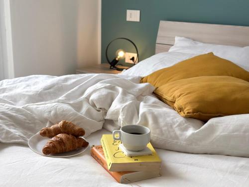 a plate of food and a cup of coffee on a bed at Aquavista Residence - Lakeview Holiday Apartments with Pool in Dormelletto