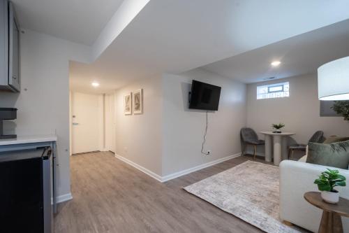a living room with a couch and a tv on the wall at A Charming Modern Chic Basement Apartment in Chicago