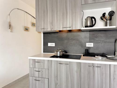 a kitchen with white cabinets and a sink and a stove at Aquavista Residence - Lakeview Holiday Apartments with Pool in Dormelletto