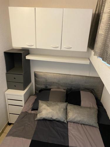 - un lit avec des placards blancs dans une chambre dans l'établissement PN1 coursives, à La Celle-sous-Gouzon