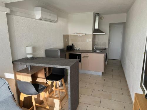 une cuisine avec une table et des chaises dans une pièce dans l'établissement PN1 coursives, à La Celle-sous-Gouzon