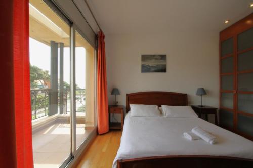 a bedroom with a bed and a large window at Beach House Castelldefels in Castelldefels