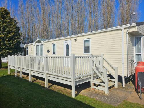 a white mobile home with a white fence at Lovely Caravan At Manor Park, Nearby Hunstanton Beach In Norfolk Ref 23029T in Hunstanton