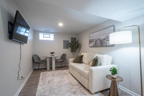 a living room with a white couch and a table at A Charming Modern Chic Basement Apartment in Chicago