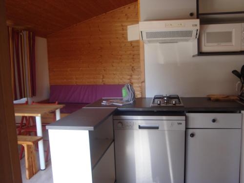 une cuisine avec une cuisinière et un comptoir dans l'établissement La Pourvoirie des Ellandes, à Excenevex