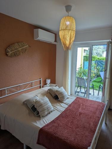 une chambre avec un grand lit et une fenêtre dans l'établissement Élégant et calme avec clim et jardin privé - Appartement Terracotta, à Thonon-les-Bains