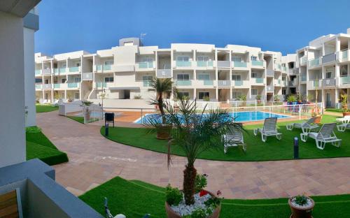 ein großes Apartmenthaus mit einem Innenhof und einem Pool in der Unterkunft Luxury Apartment in Corralejo