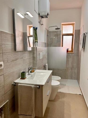 a bathroom with a sink and a toilet and a mirror at House on the beach in Lido Marini