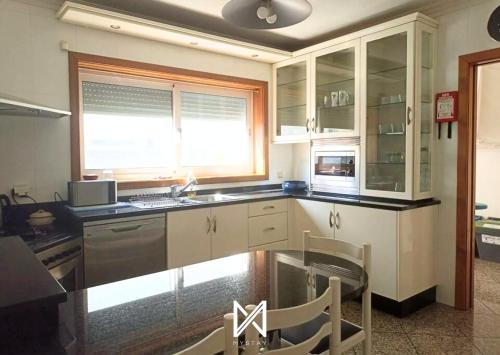 a kitchen with white cabinets and a counter top at MyStay - Villa Luísa in Vila do Conde