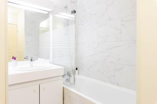 une salle de bain blanche avec une baignoire et un lavabo dans l'établissement Lyon 8 Beautiful, bright and quiet apartment, à Lyon