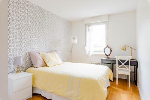 une chambre blanche avec un lit et un bureau dans l'établissement Lyon 8 Beautiful, bright and quiet apartment, à Lyon