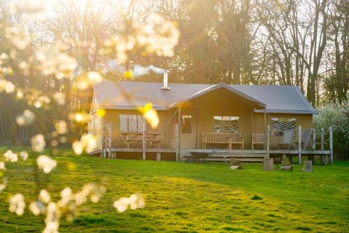a small yellow house in a field of grass at Cuckoo - Sweffling Hall in Rendham