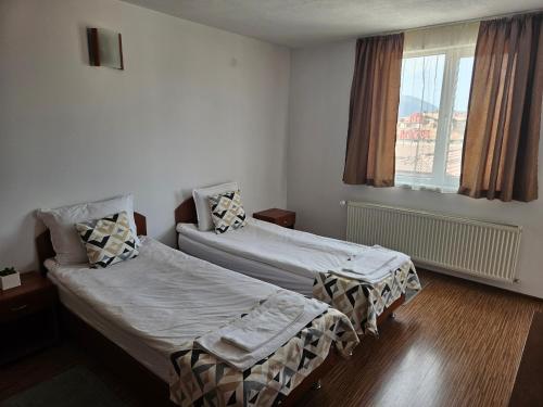 a bedroom with two beds and a window at Cтаи за гости Бърдареви in Bansko